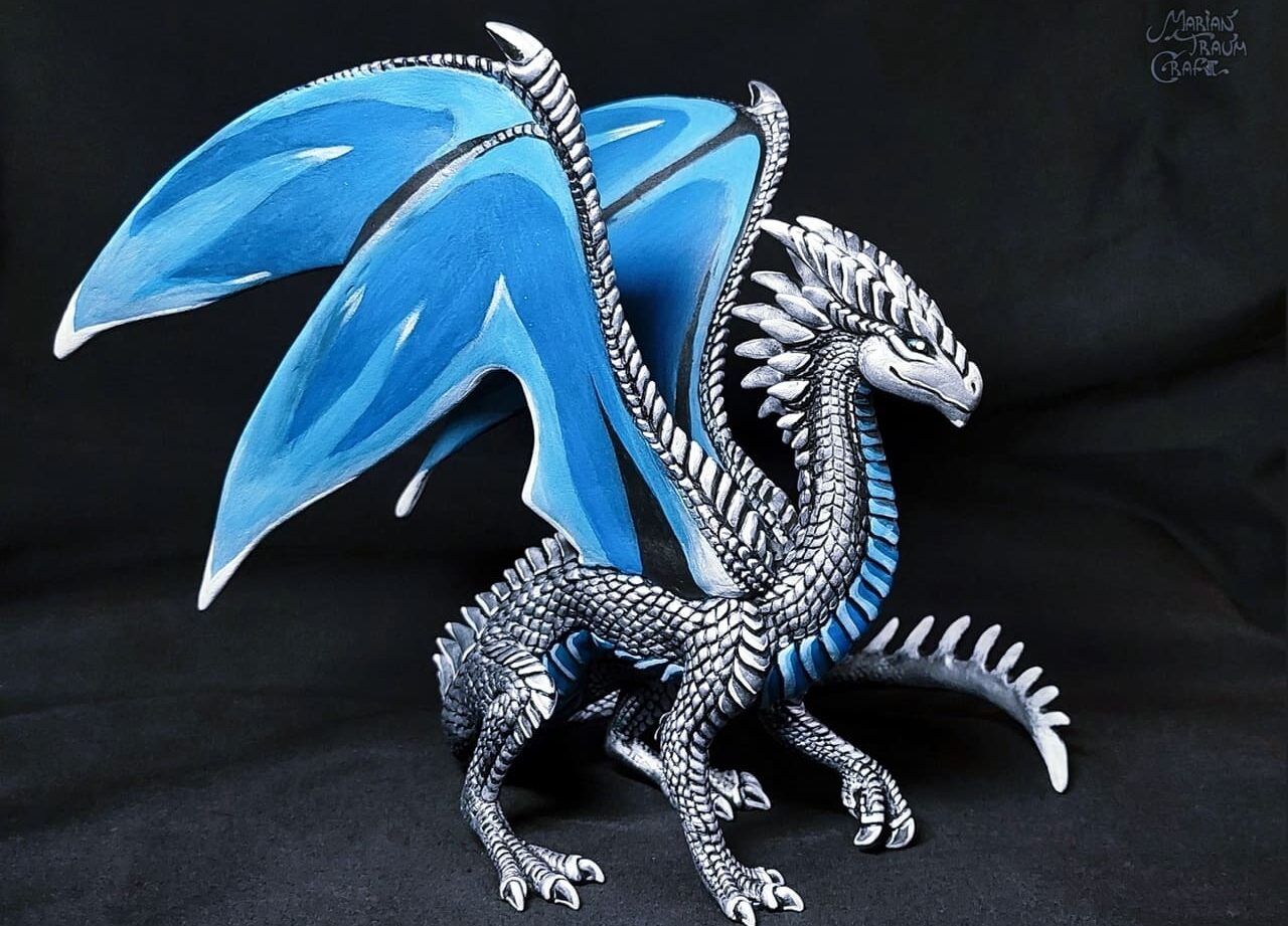 Скульптура серебряного дракона с голубыми крыльями